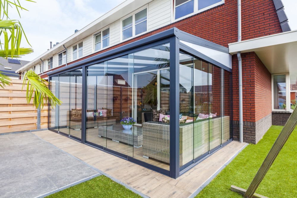 Pergola aluminium à toit en verre fermée par des parois vitrées